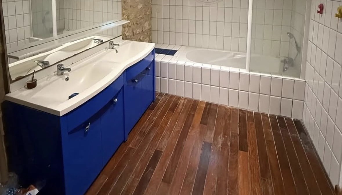 Salle de bain avant rénovation : vanité bleue, bain podium et céramique vieillotte